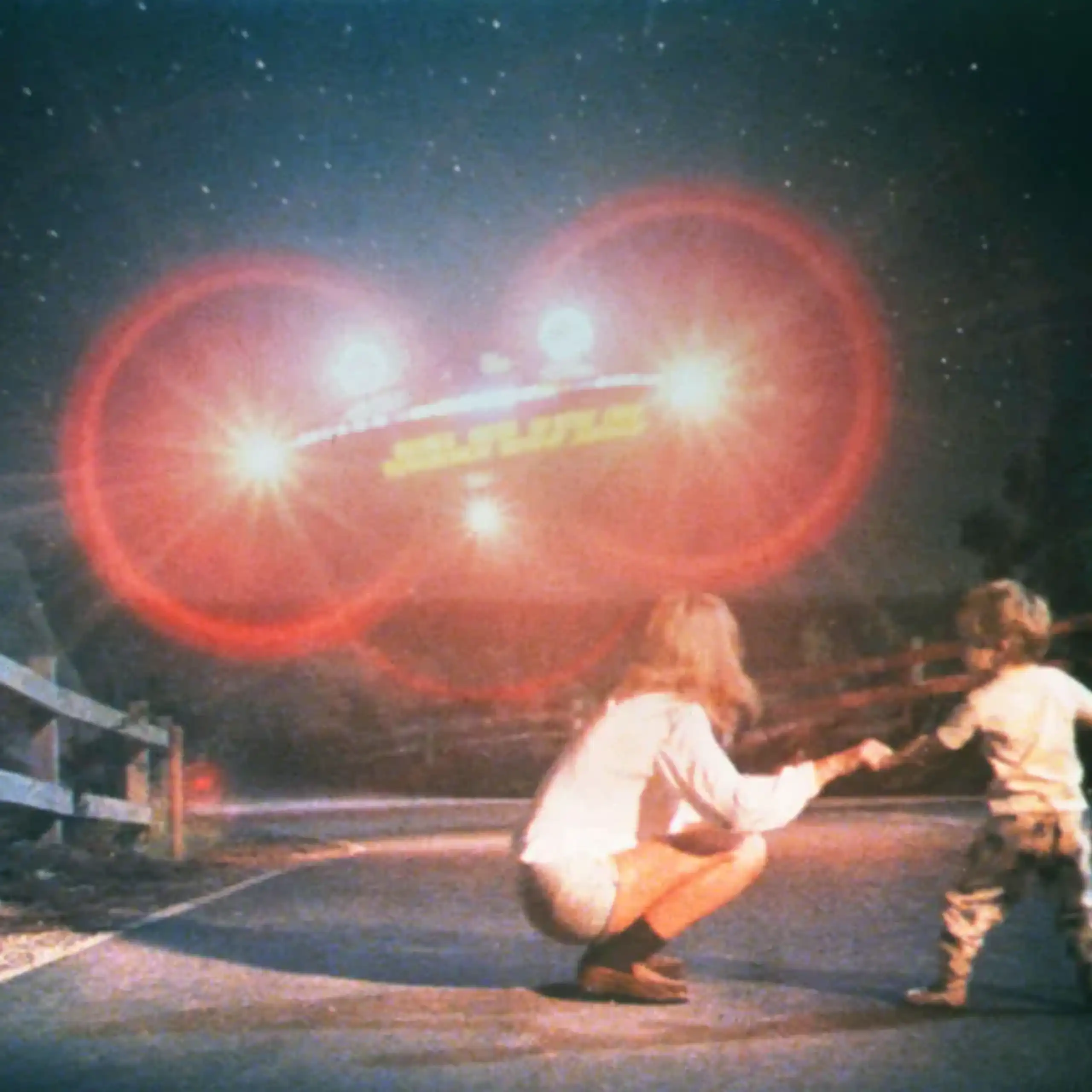 Capture d'écran : l'enfant et sa mère, en pleine nuit, face à une machine volante avançant plein phare dans leur direction.