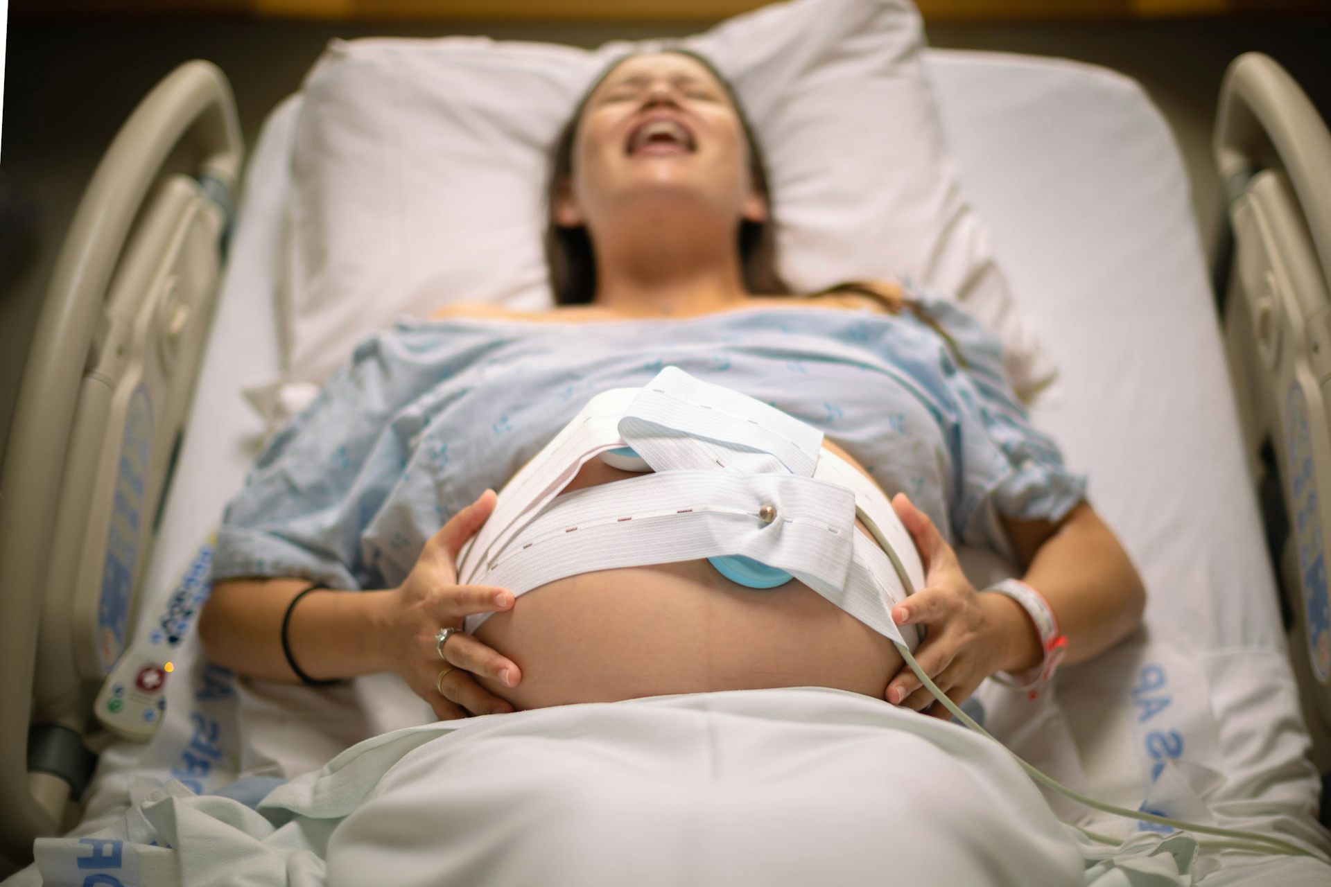 A woman having painful contractions, lying in a hospital bed, waiting for labour.