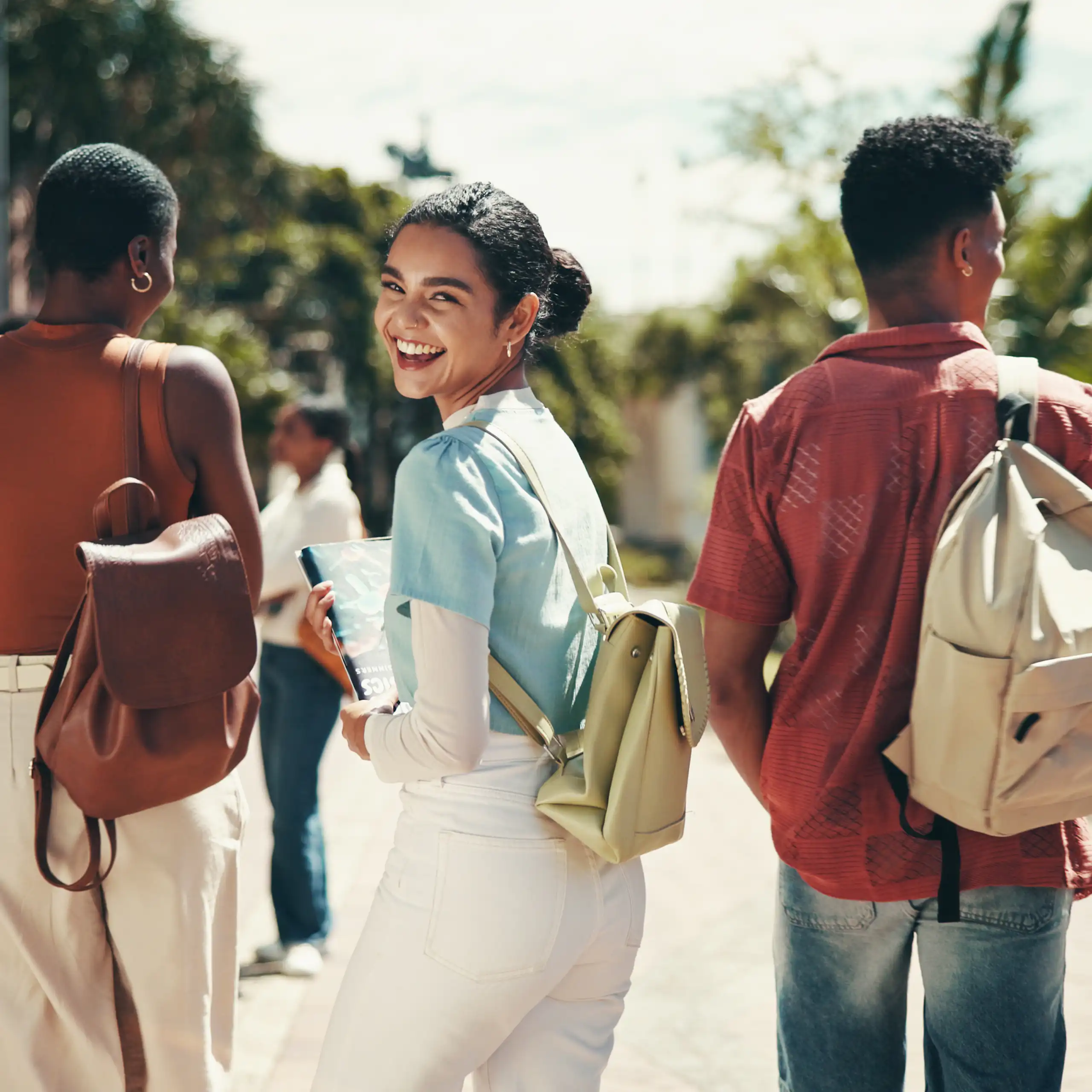 Group of young people walking; girl looks back smiling