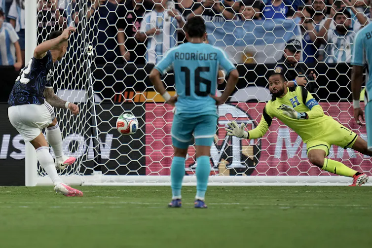 ¿Actuar bajo presión? Para los deportistas depende de 3 cosas clave 1 El futbolista se sitúa de cara a la red mientras el portero salta a por el balón.