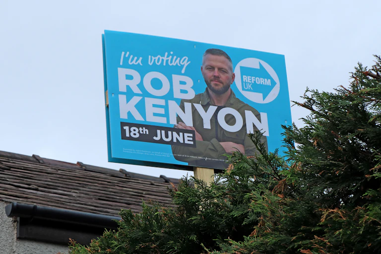 poster outside a house showing reform uk candidate robert kenyon