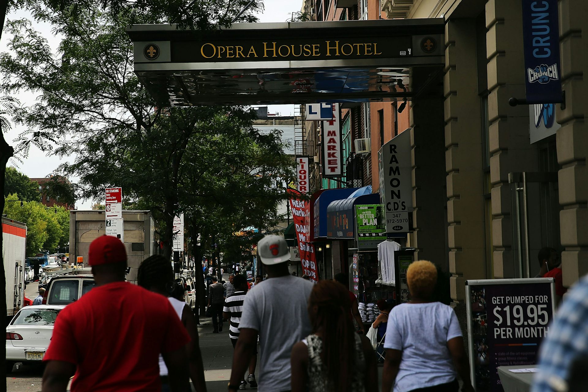 La gente camina por la calle cerca del edificio que dice Hotel Opera.