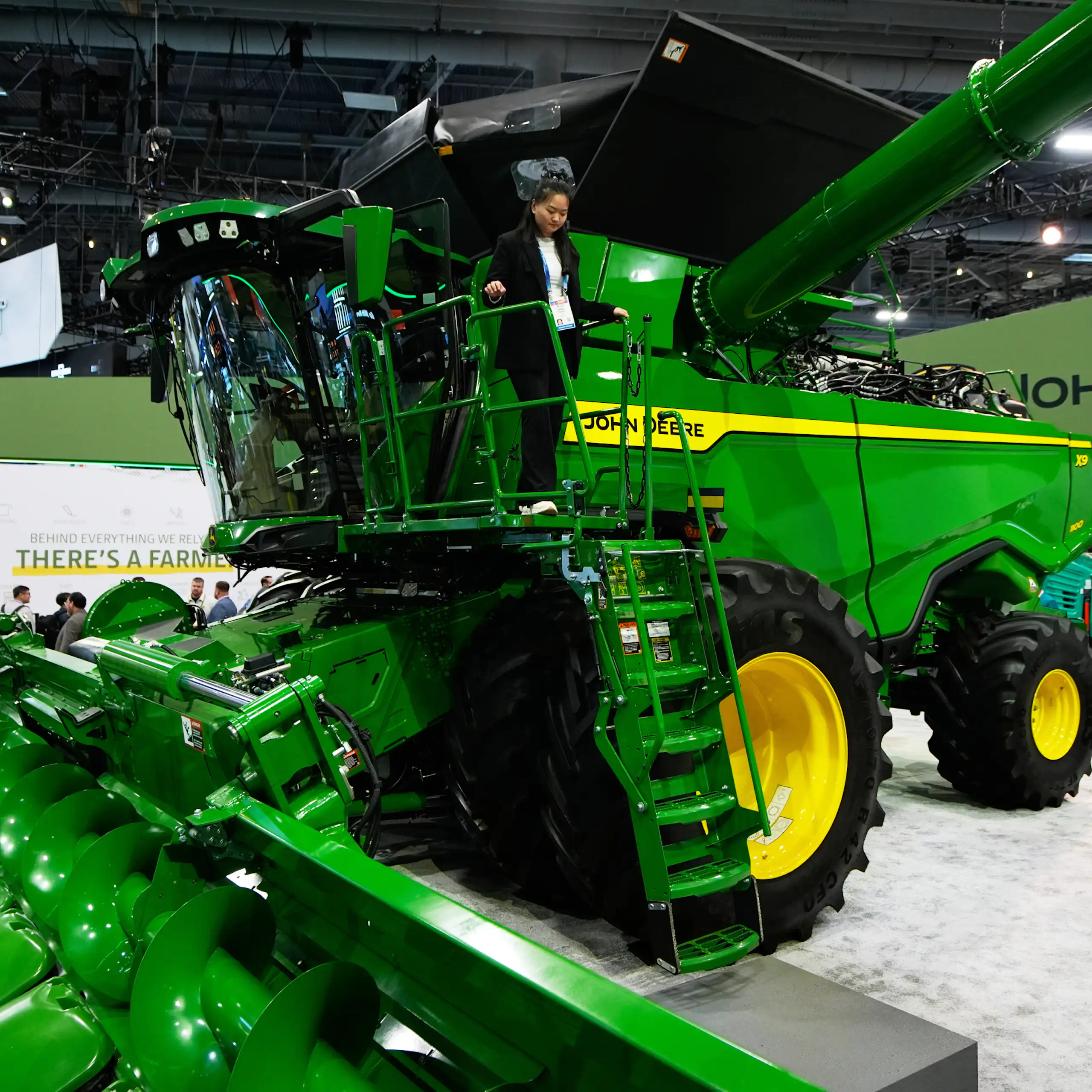 A customer walks on a massive green combine at the John Deere booth during the 2026 CES tech show in Las Vegas, Nevada.