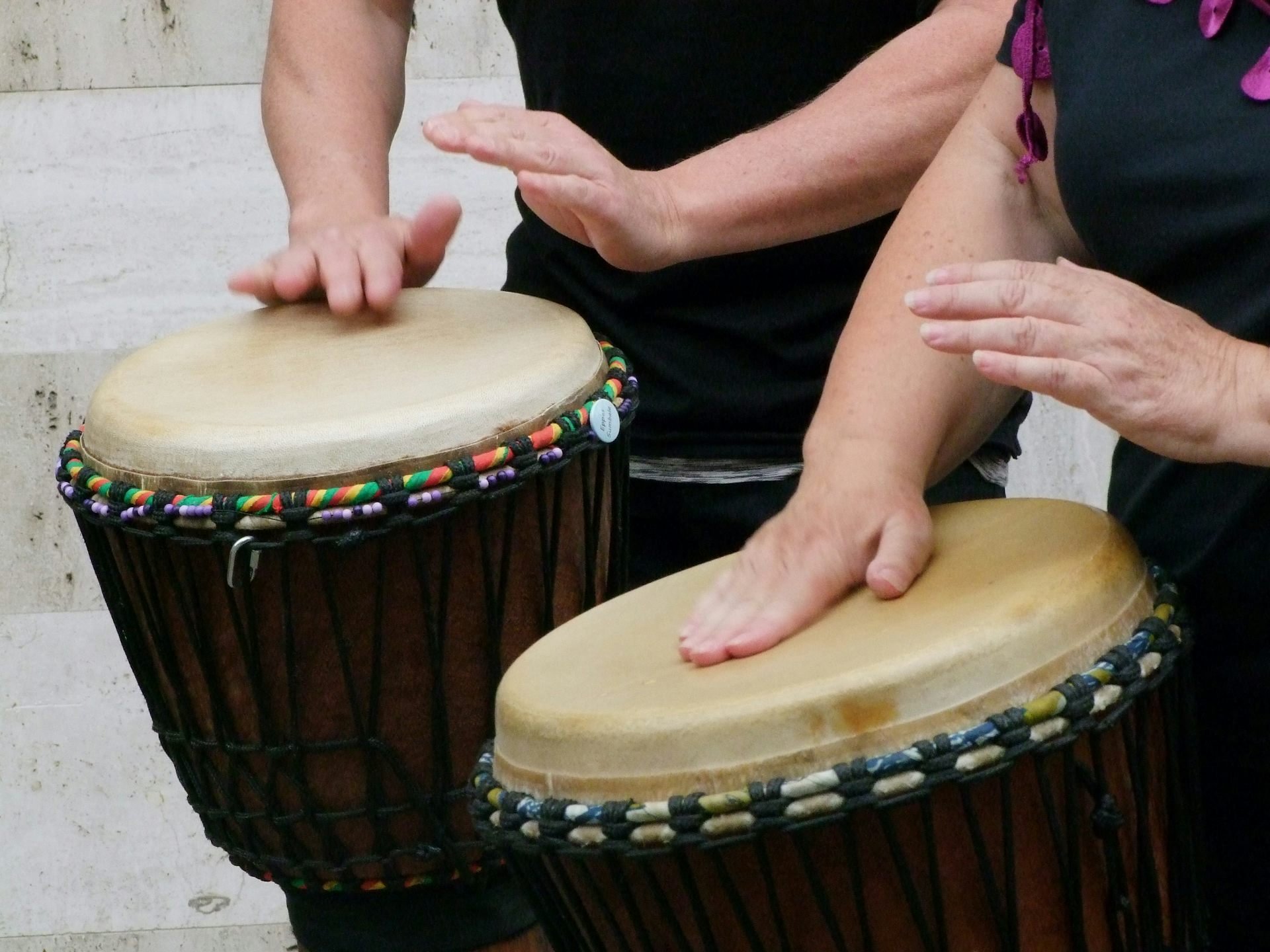 Close-up photo of two people's hands playing drums