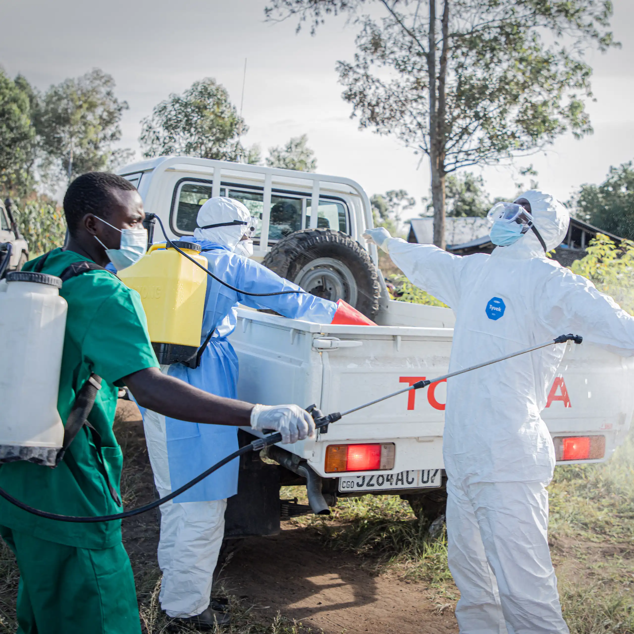 Des bénévoles se désinfectent après l'enterrement d'un enfant de 3 ans, présumément décédé des suites de la maladie à virus Ebola, à Bunia, en république démocratique du Congo, le 11 juin 2026.
