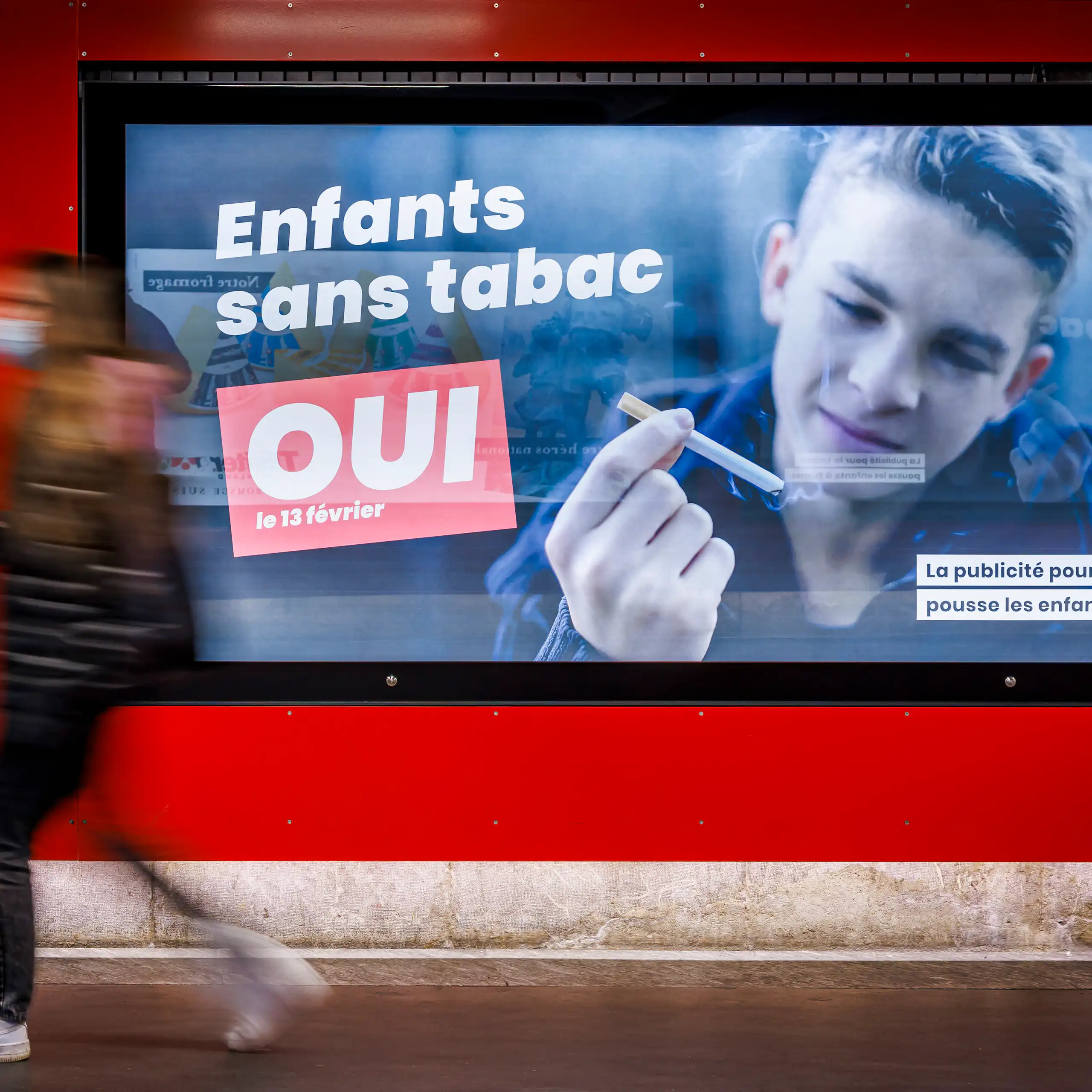 Affiche avec un jeune tenant une cigarette, sur laquelle on peut lire en français : « Des enfants sans tabac, OUI (La publicité pour le tabac pousse les enfants à fumer)».