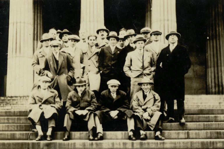 Photo de groupe des membres masculins du club posant sur les marches de l'entrée d'un monument ou du club lui-même.
