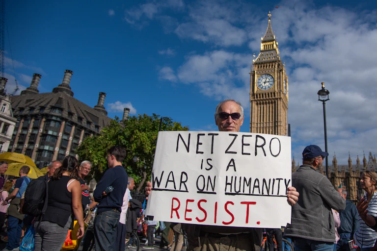 man holds anti-net zero sign in Westminster