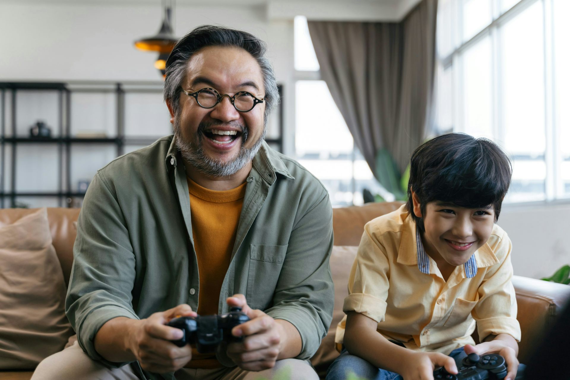 Un homme et un garçon souriant en jouant à un jeu vidéo