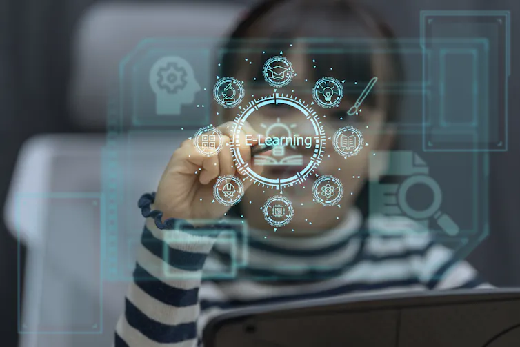A young girl looks at a screen that has blue graphics and says 'E-learning.' She touches it with her finger.