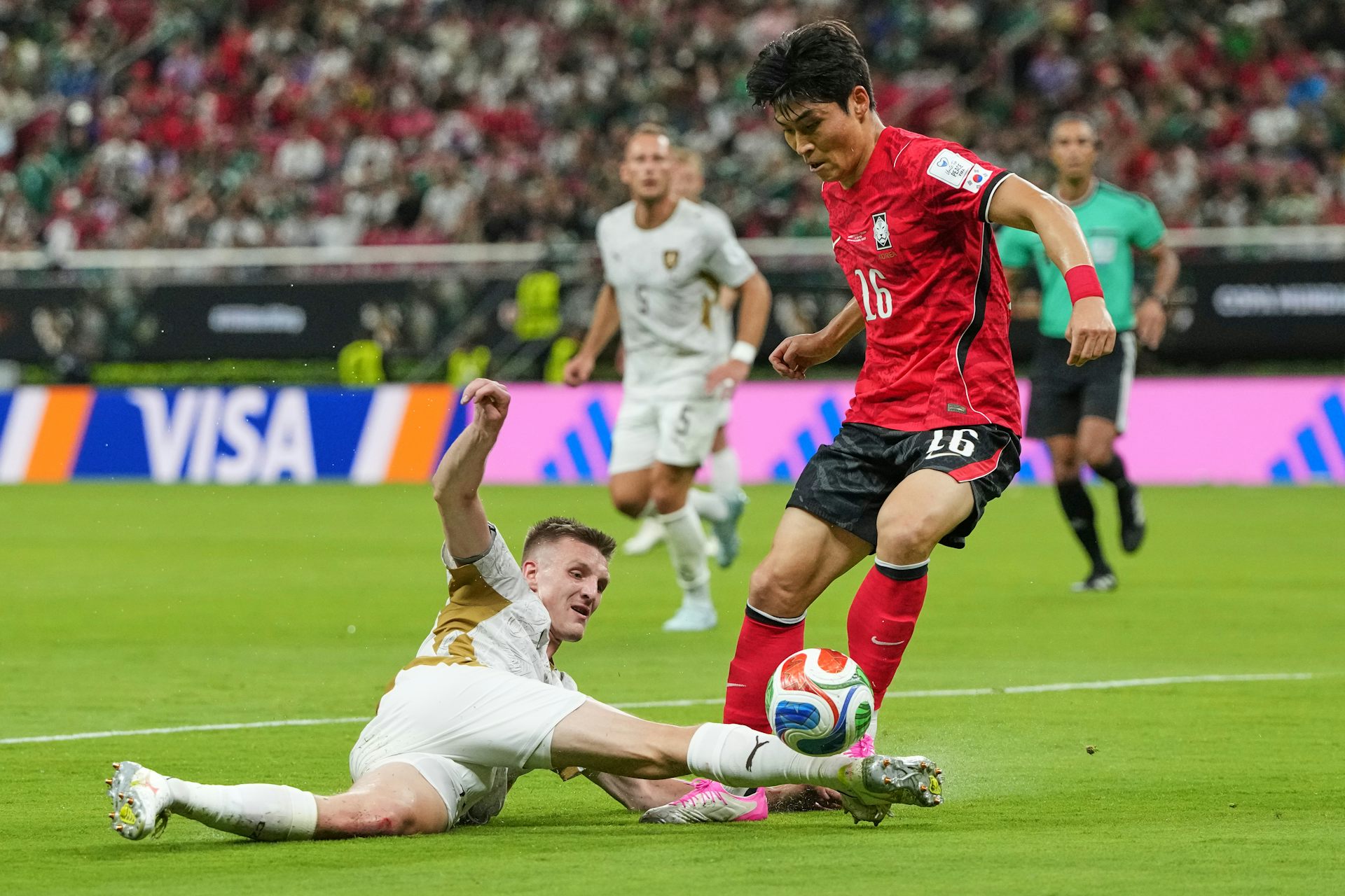 Dos jugadores de fútbol en el campo luchan por el balón.