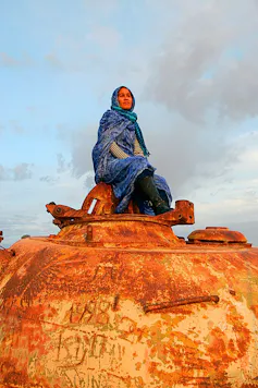 Pedro Sánchez defiende la autodeterminación en Ucrania y la niega en el Sahara: ¿por qué? 1 Una mujer saharaui mira el horizonte desde un tanque abandonado en Tifarita (Sáhara Occidental)