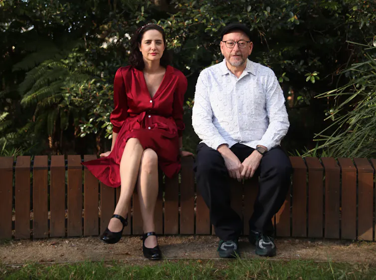 a woman in a red dress and a man in white shirt and black pants