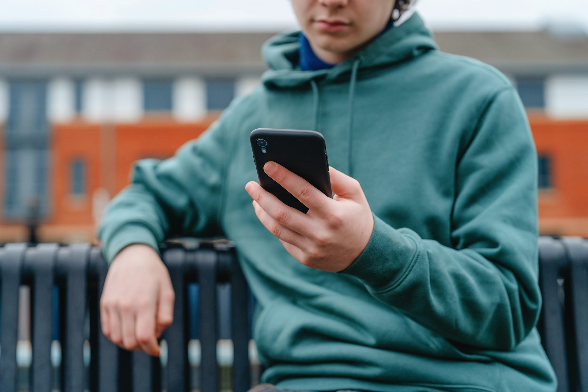 Boy on bench looking at phone