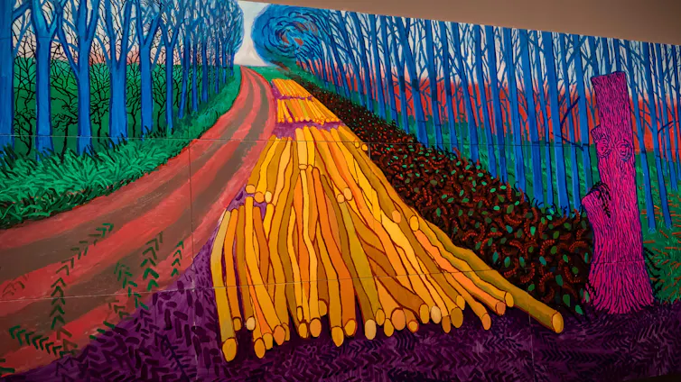 A painting of a rural scene showing a path through some trees in vivid pinks, blues and greens.