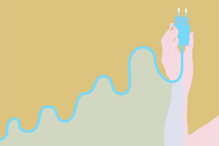 A hand holds an electric plug as its wire forms the shape of a rising-trend graph.