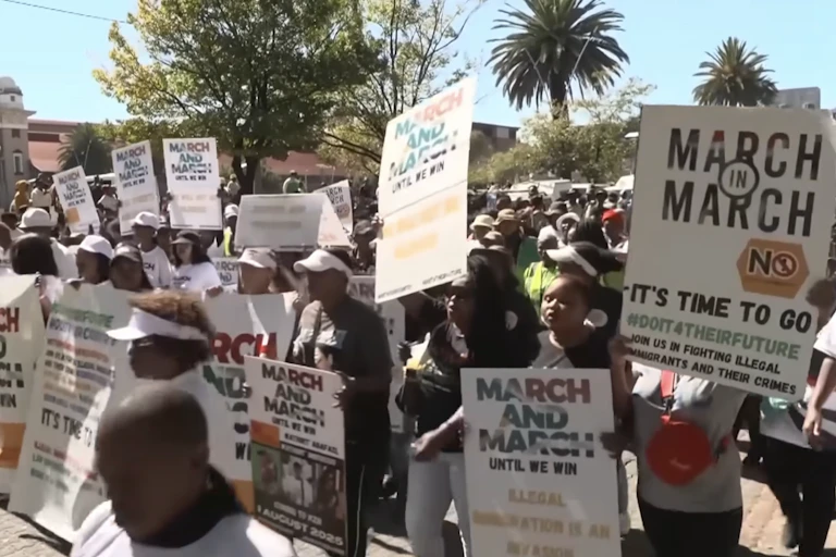 A group of people outdoors, holding placards
