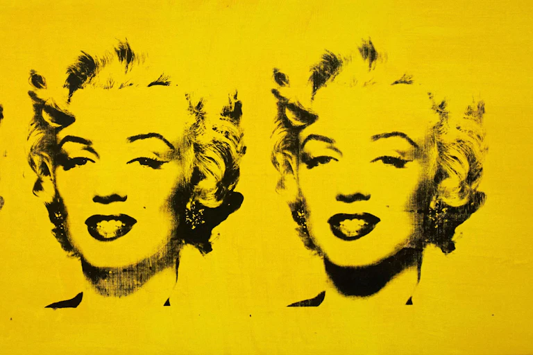 A Warhol print black on yellow of Marilyn Monroe's classic portrait.