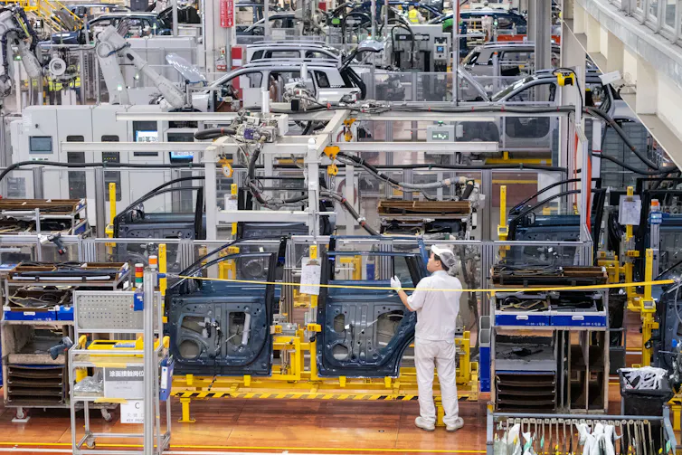 electric car factory, one factory worker in view