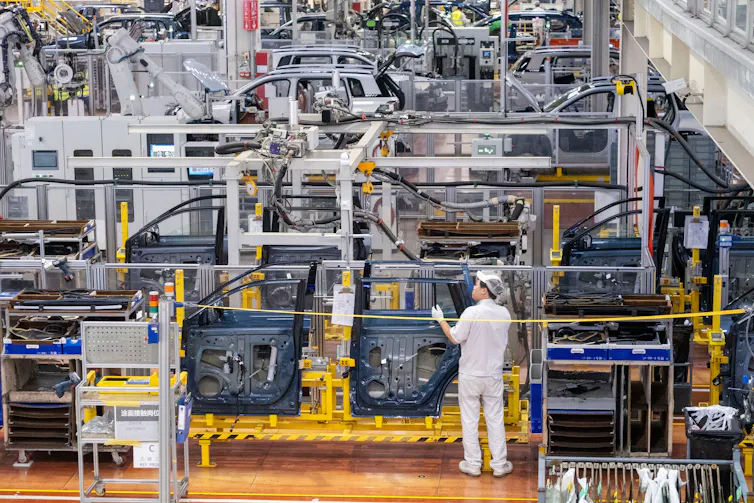 electric car factory, one factory worker in view