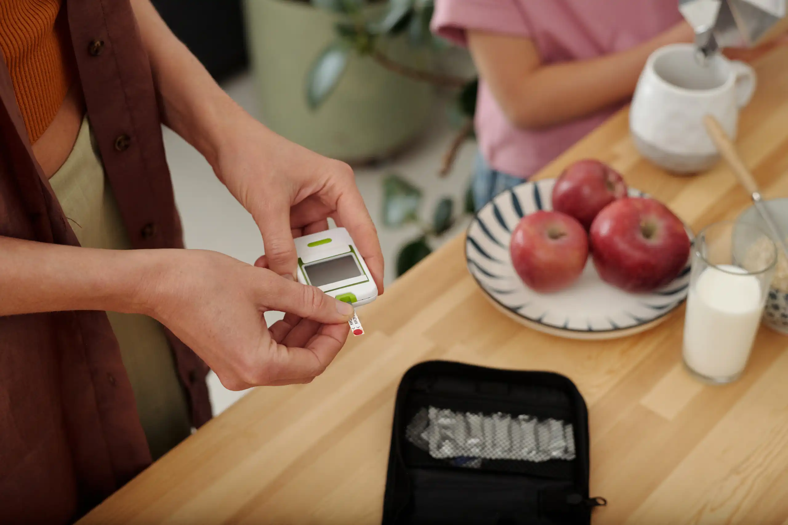 A woman is holding a glucose meter