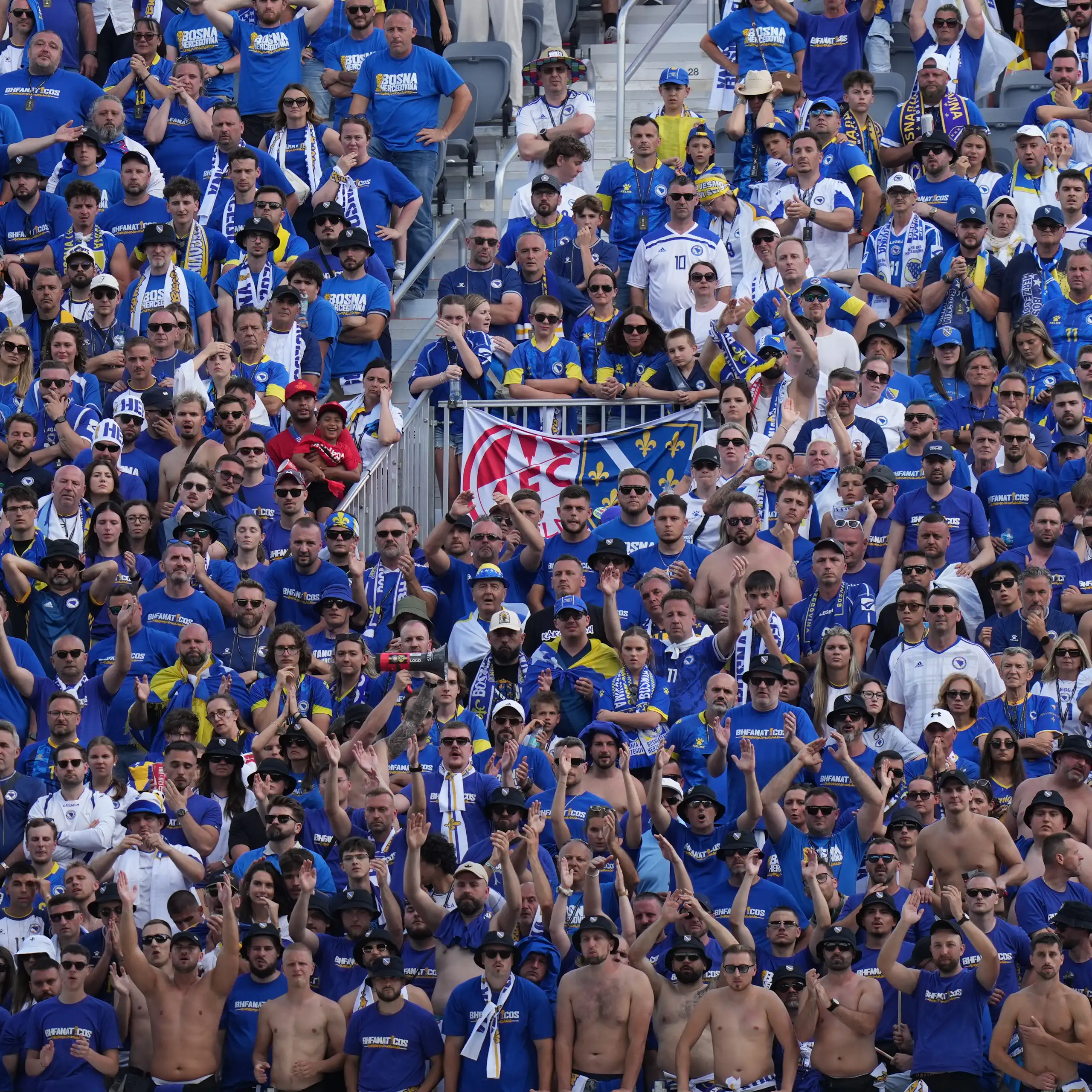 A crowd of people in stands at a soccer match.