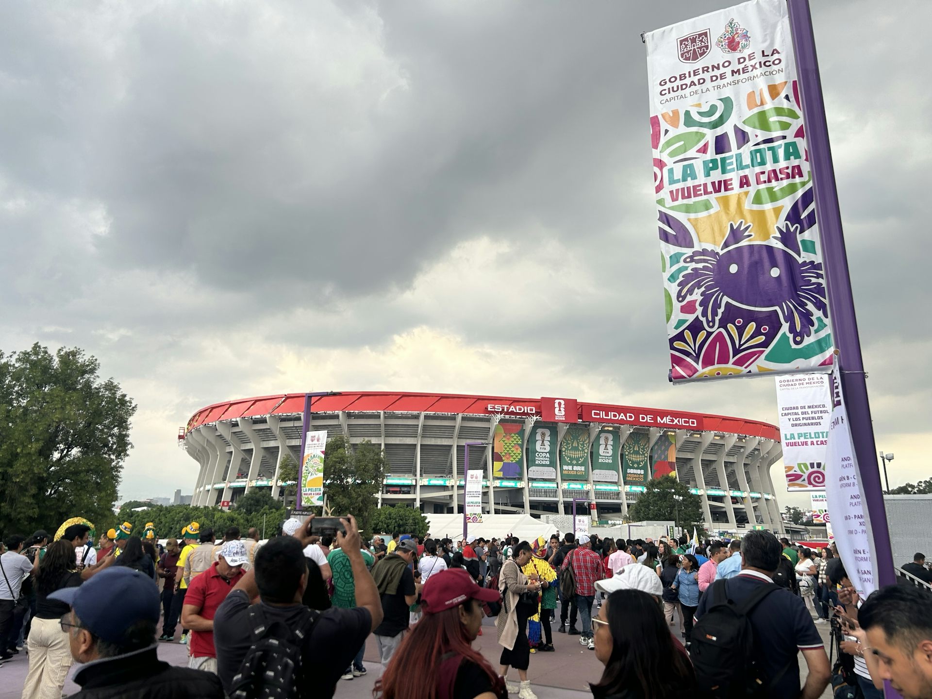 Muchedumbre con un estadio al fondo.