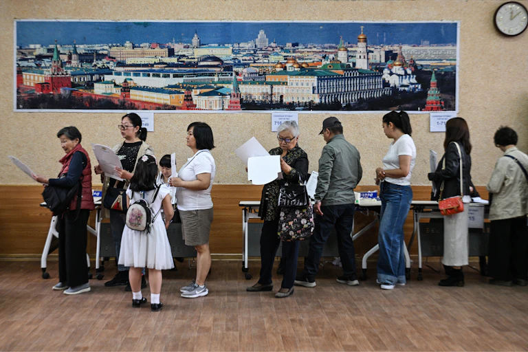 des électeurs font la queue pour voter.