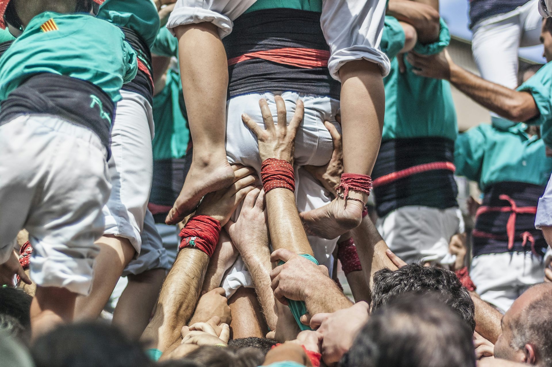Moltes mans sostenen un castell de persones.