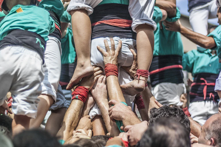 Moltes mans sostenen un castell de persones.