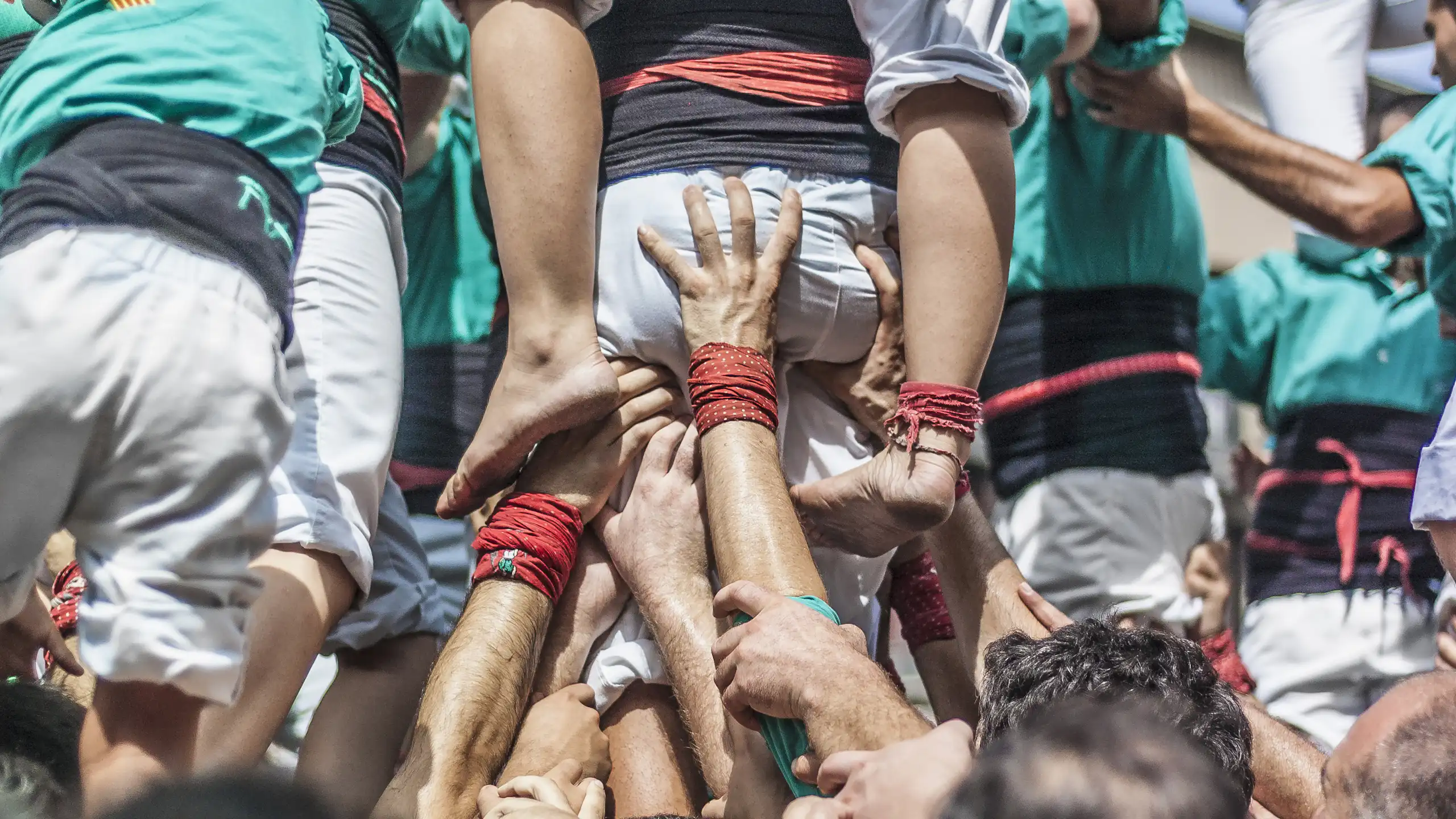 Moltes mans sostenen un castell de persones.