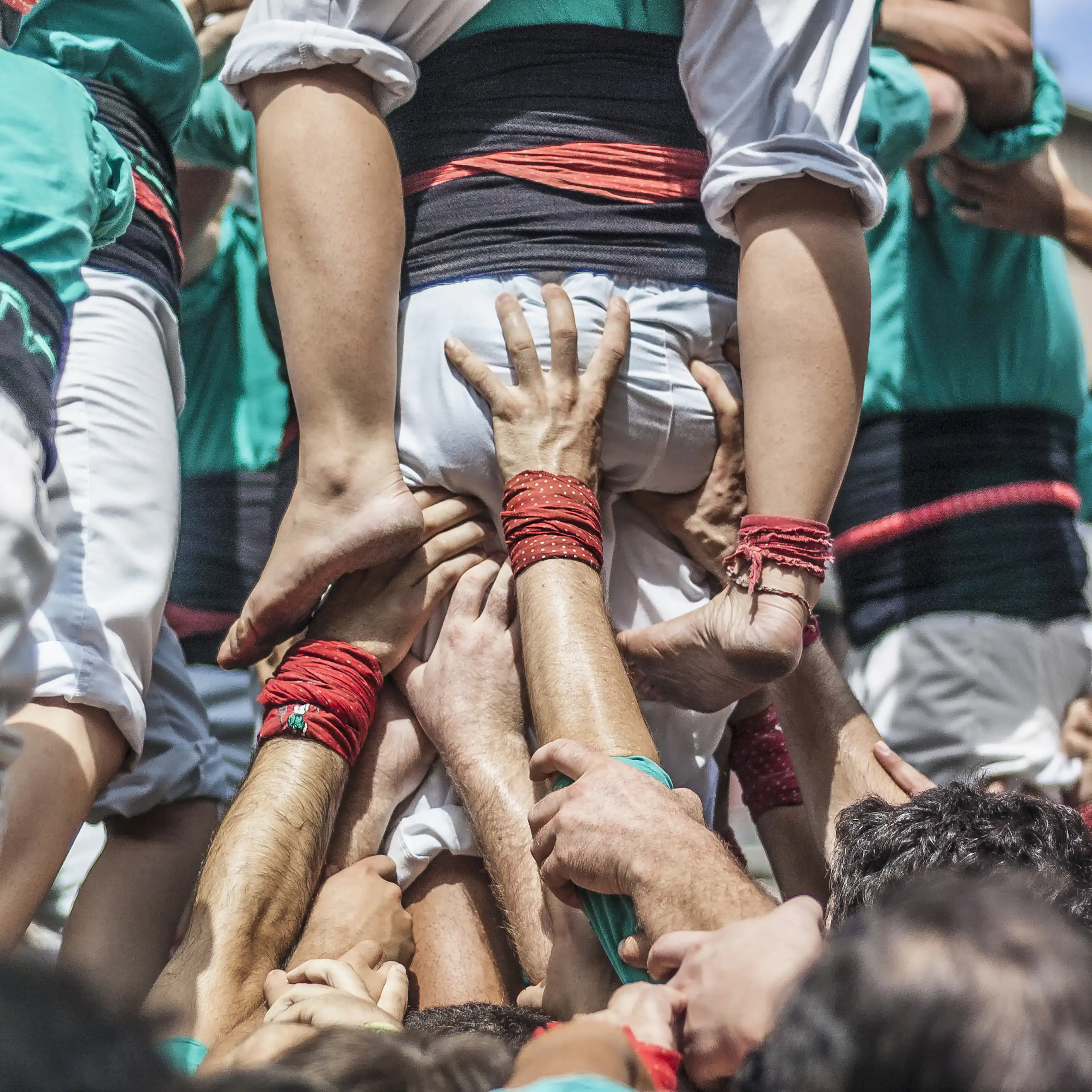 Moltes mans sostenen un castell de persones.