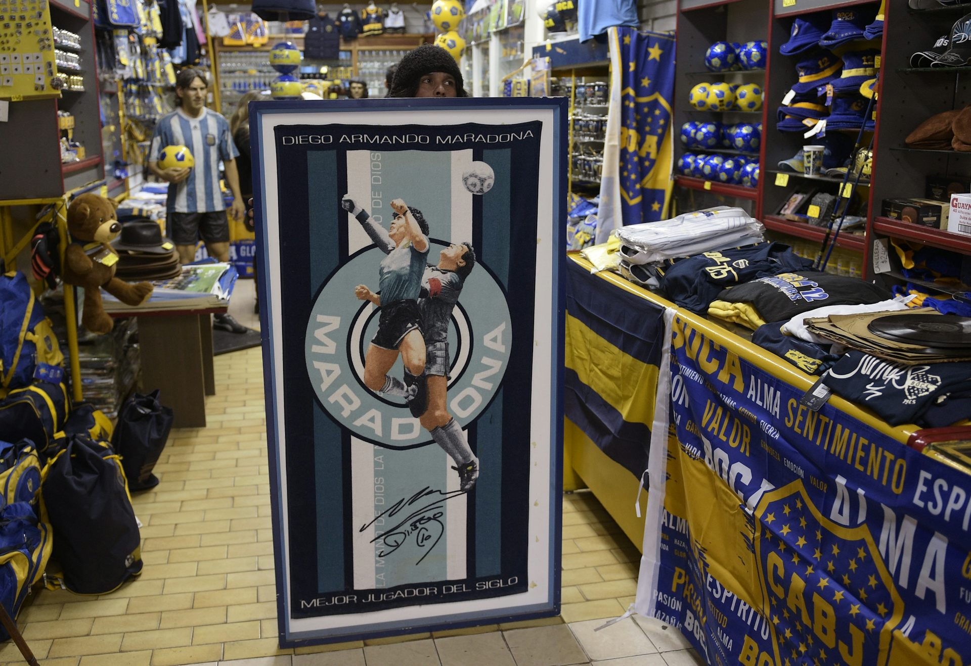 A shop worker holds a large towel.