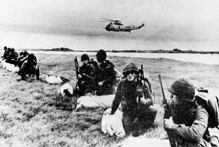 40 años después, el gol de la 'Mano de Dios' de Maradona todavía se celebra. ¿Pero debería ser así? 2 Soldados uniformados en la playa con un helicóptero al fondo.
