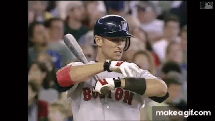 A baseball player in a Boston Red Sox uniform prepares to pitch.