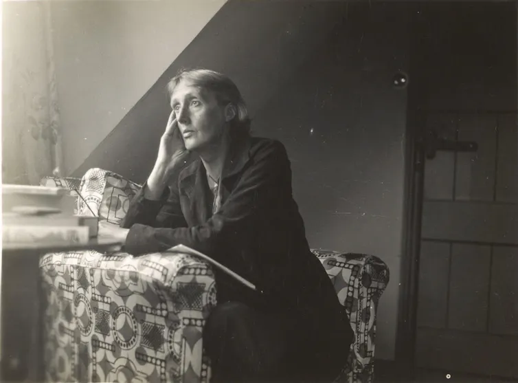 A woman sits gazing out a window.