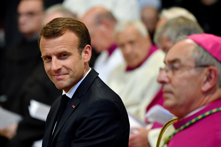 Le président français Emmanuel Macron (à gauche) prend place dans la cathédrale du pape, l’archibasilique Saint-Jean-de-Latran à Rome, le 26 juin 2018, lors de la cérémonie au cours de laquelle il a été nommé premier et unique chanoine honoraire de l’archibasilique Saint-Jean-de-Latran. Le président français Emmanuel Macron a effectué sa première visite officielle au Vatican, où il a eu un entretien exceptionnellement long avec le pape François. (Photo : Alberto PIZZOLI / AFP)