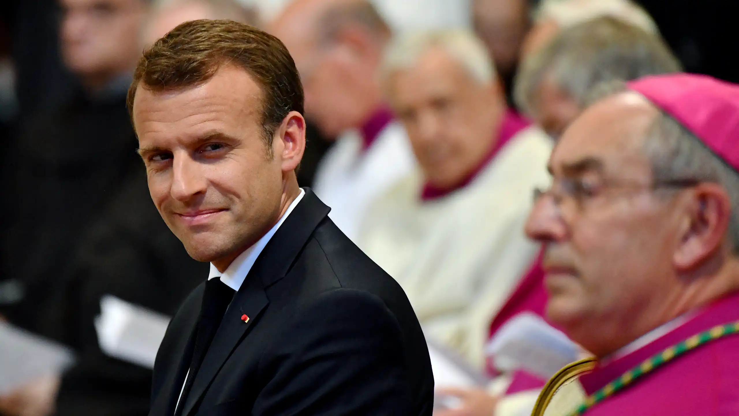 Le président français Emmanuel Macron (à gauche) prend place dans la cathédrale du pape, l’archibasilique Saint-Jean-de-Latran à Rome, le 26 juin 2018, lors de la cérémonie au cours de laquelle il a été nommé premier et unique chanoine honoraire de l’archibasilique Saint-Jean-de-Latran. Le président français Emmanuel Macron a effectué sa première visite officielle au Vatican, où il a eu un entretien exceptionnellement long avec le pape François. (Photo : Alberto PIZZOLI / AFP)