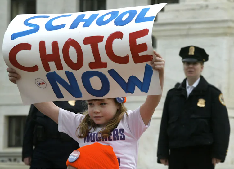 Young girl holds up a sign that says School Choice Now