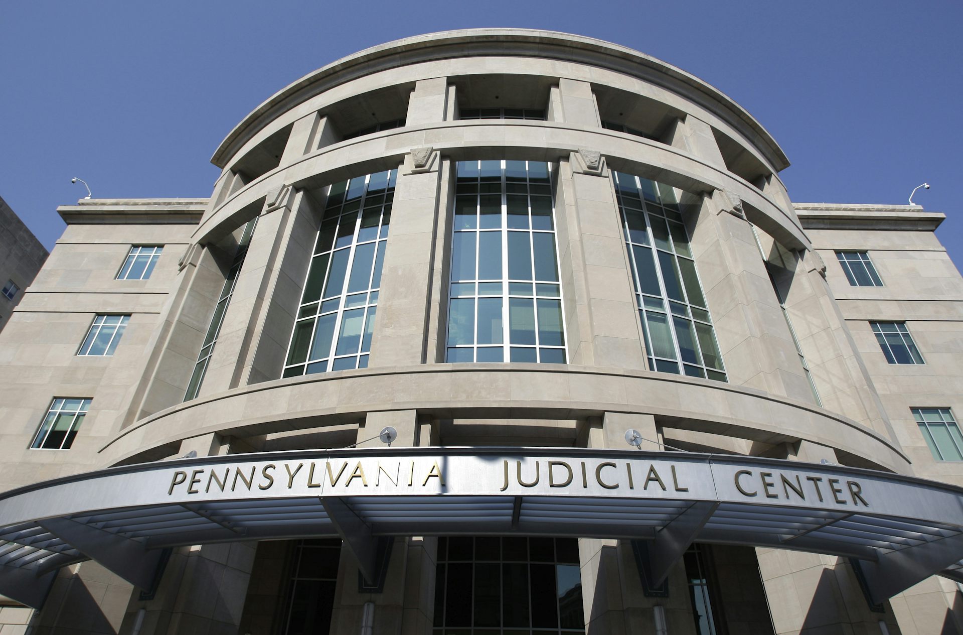 Exterior of grey concrete building with sign that says 'Pennsylvania Judicial Center'
