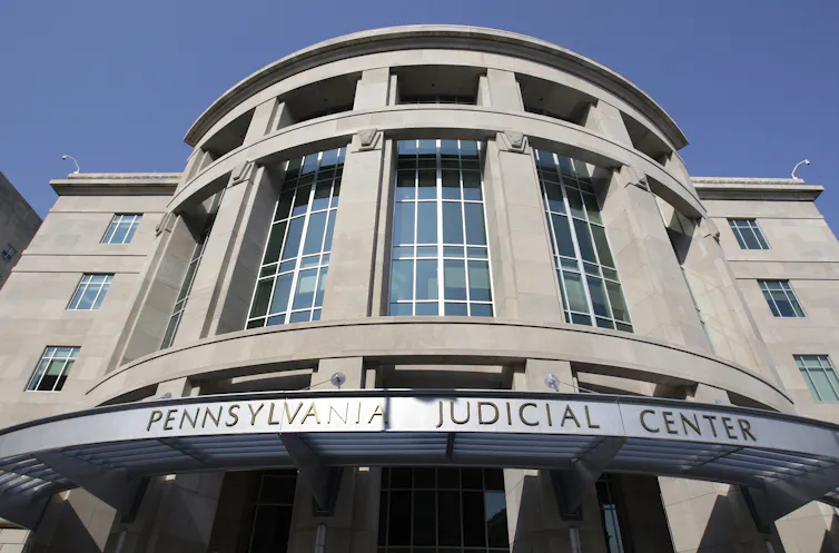 Exterior of grey concrete building with sign that says 'Pennsylvania Judicial Center'