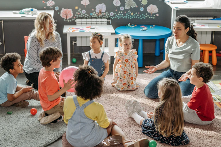 Children in circle time with educators, engaging in a kindergarten classroom activity.