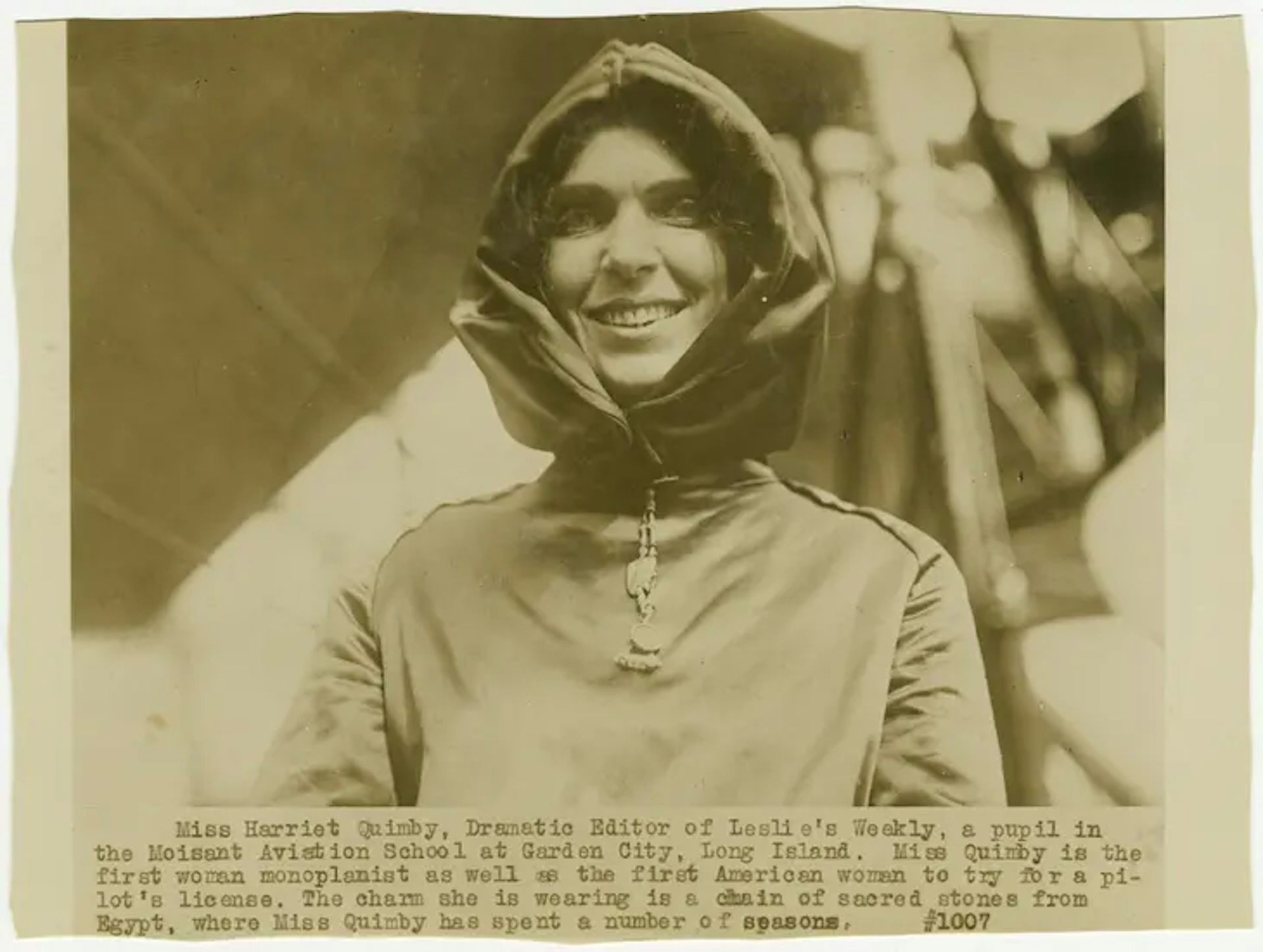 Fotografía en blanco y negro de una mujer sonriente con un traje de vuelo