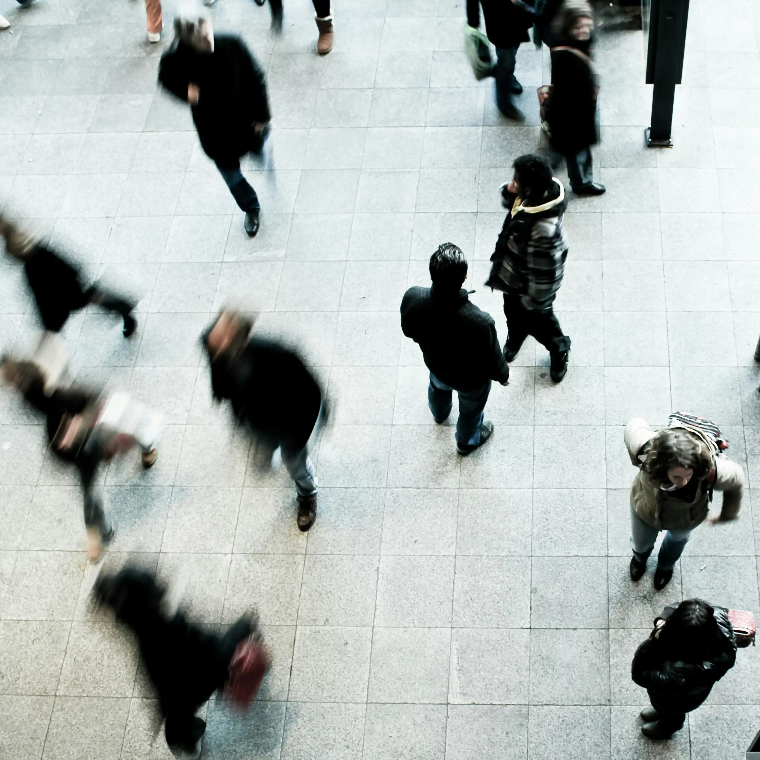 People walking past each other, with some not clearly visible