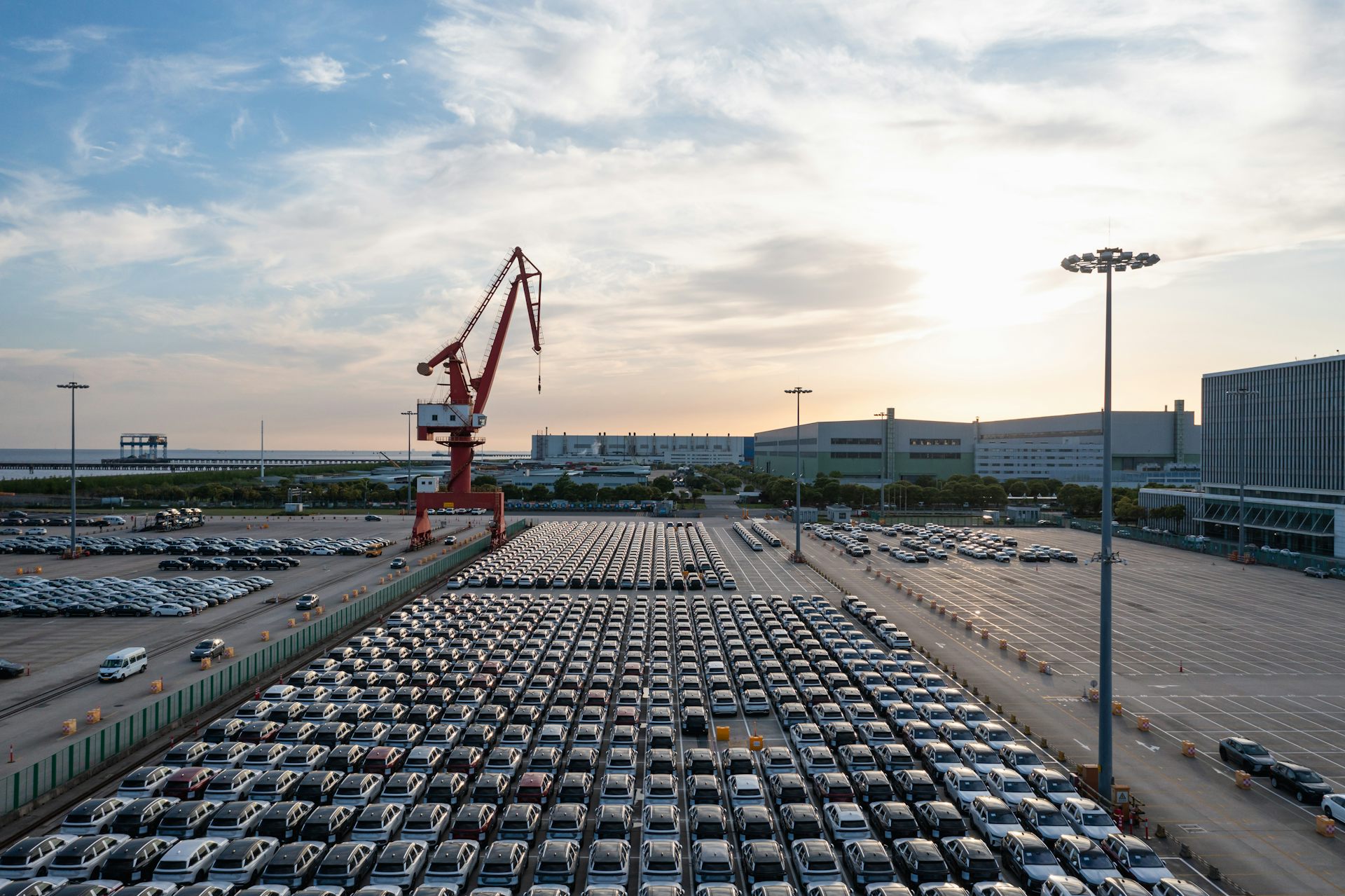 electric vehicles at a port waiting to be loaded onto a ship.