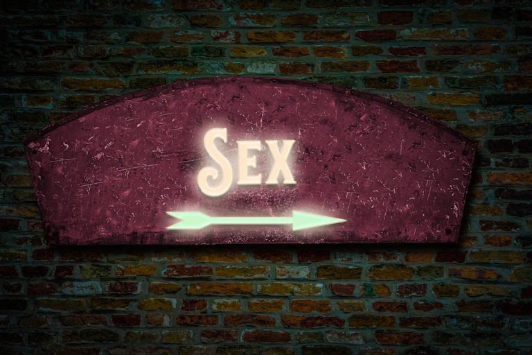 En una paret de rajola es llig la paraula "Sex" en un rètol lluminós.