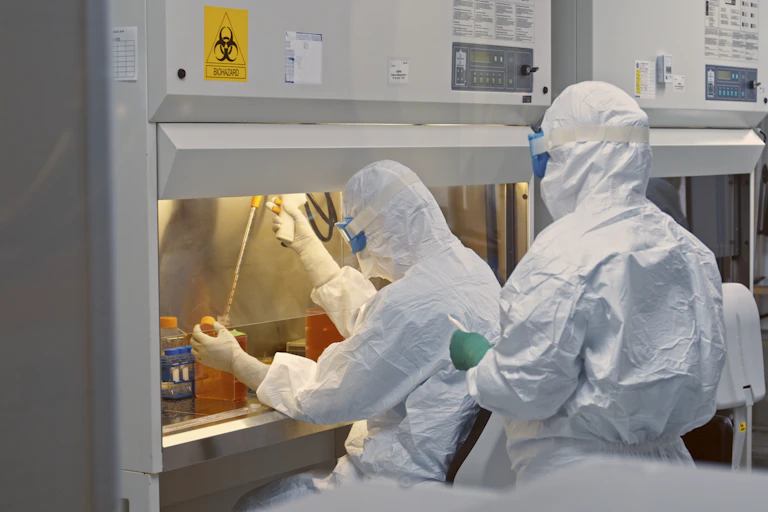 investigadores vestidos de blanco en el laboratorio