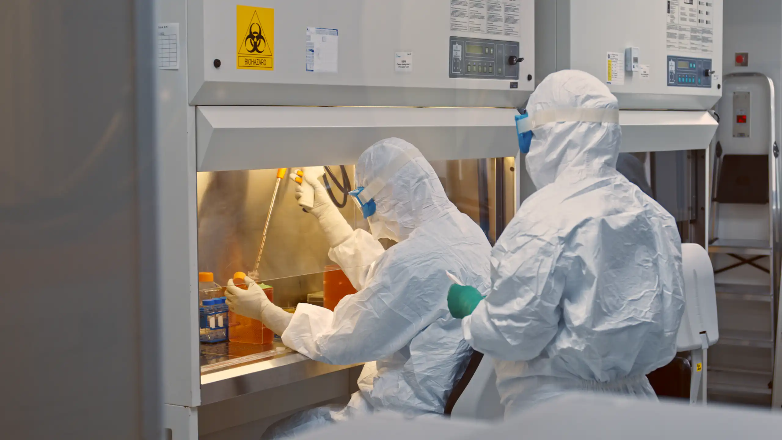 investigadores vestidos de blanco en el laboratorio