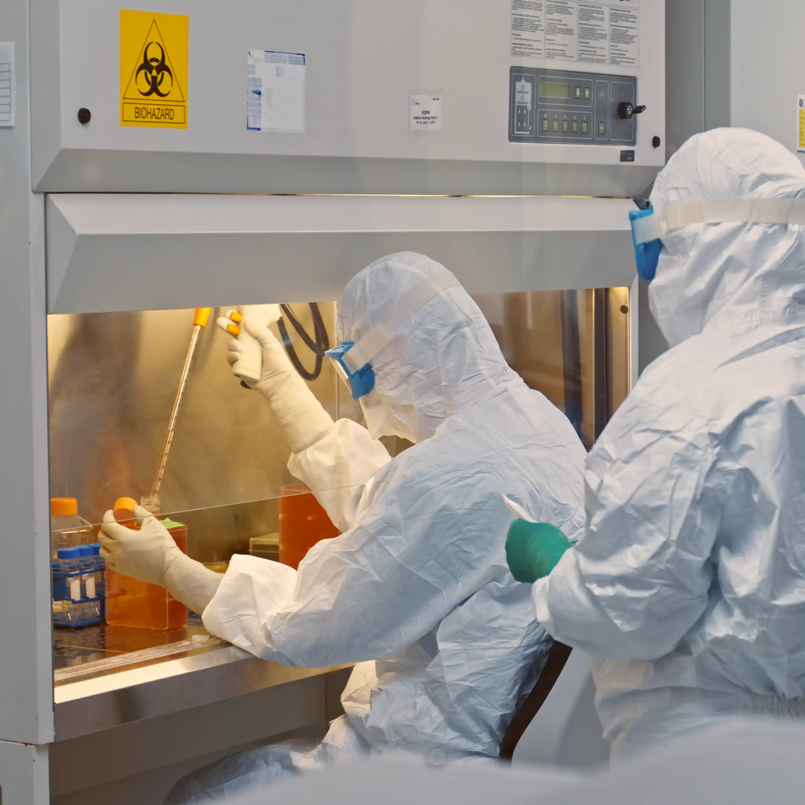 investigadores vestidos de blanco en el laboratorio