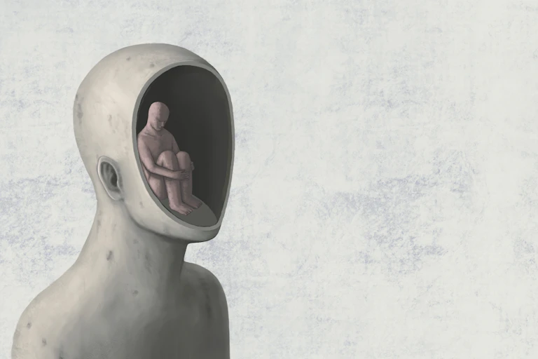 Una il·lustració d'una persona asseguda a terra dins d'un cap més gran obert per la meitat, sense monyo ni cara.